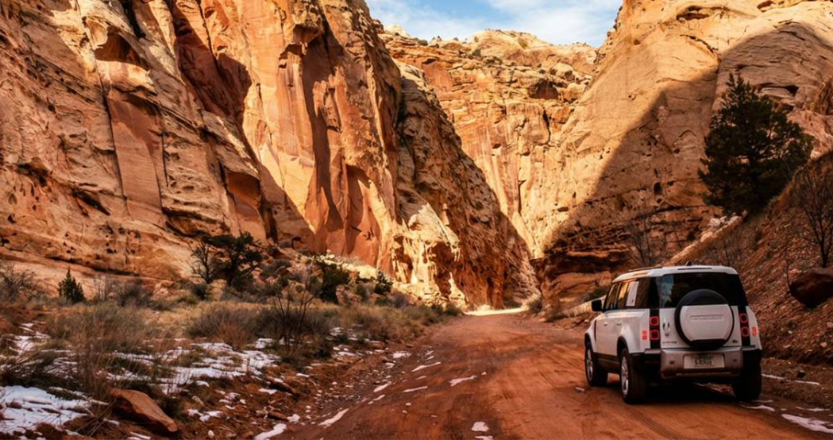 Car driving through a canyon landscape in the United States, symbolizing U.S. travel and tourism.