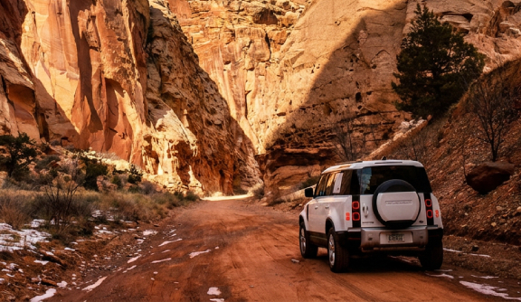 Car driving through a canyon landscape in the United States, symbolizing U.S. travel and tourism.
