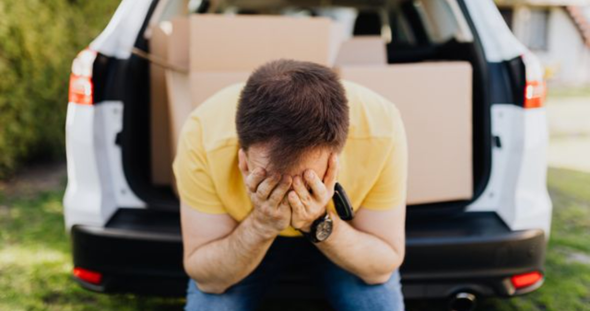 Frustrated man sitting in a rental car after making a car rental mistake